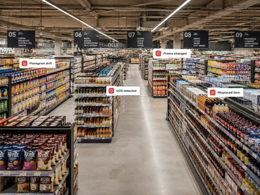 Drop: large hypermarket aisle, wide shot showing operational scale — many shelf sections